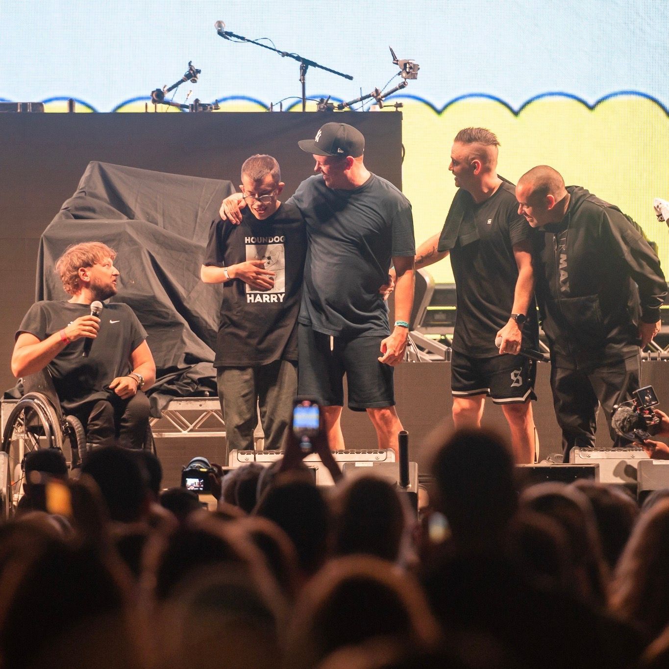 Dylan (left) with recipient Harry (middle) and Hilltop Hoods (right) on stage at Ability Fest.