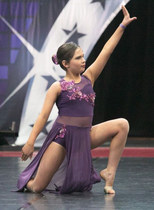 Recipient Tilly, posing in a purple costume for dance routine.