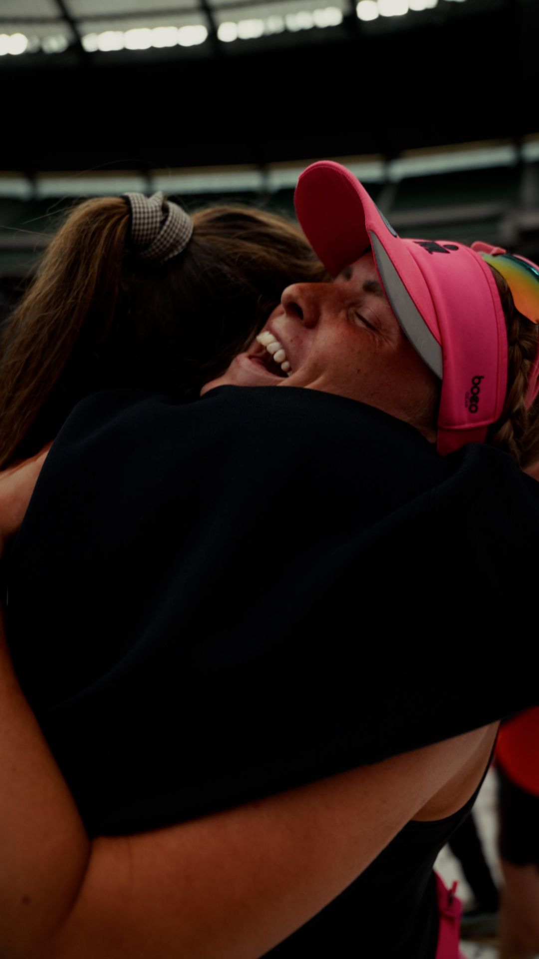 Two women hugging post race and smilling