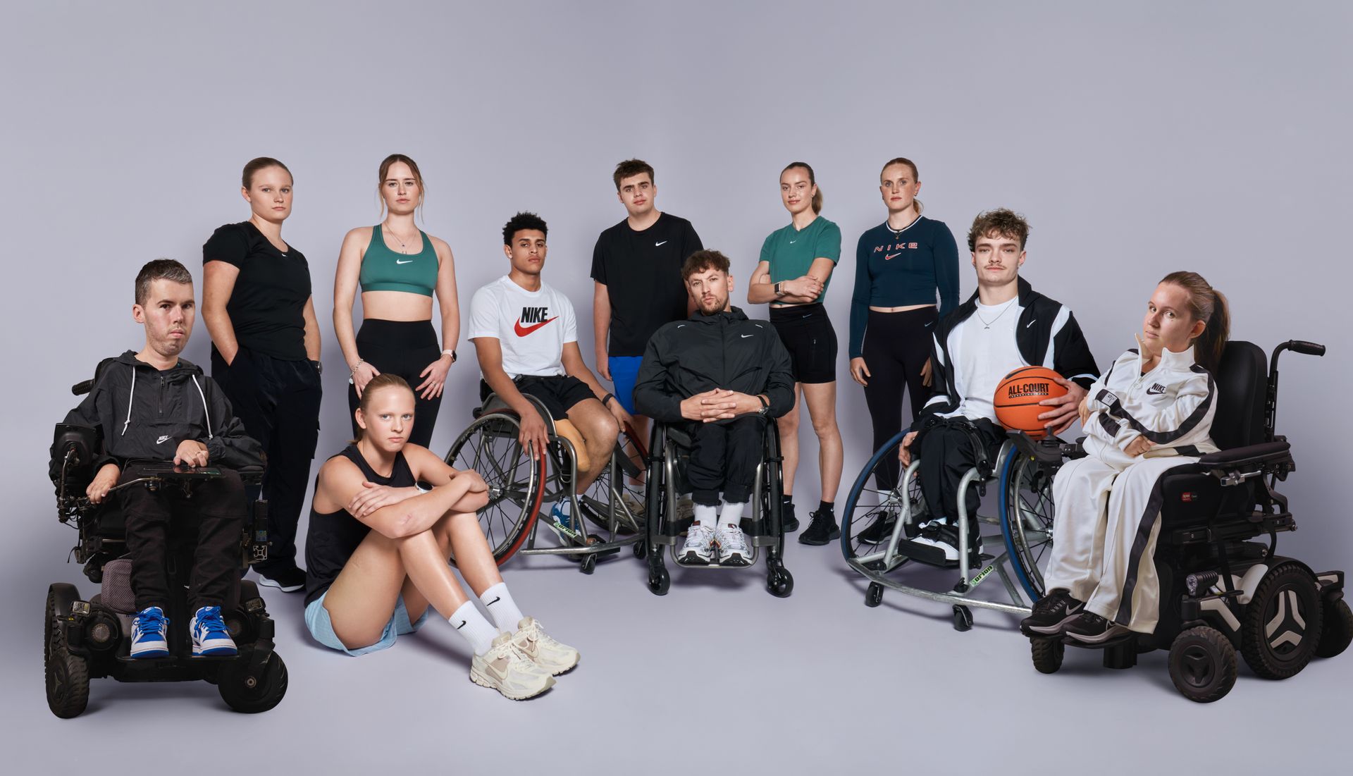 Group photo of 11 athletes and Dylan all with varying disability. All individuals wear Nike kit.