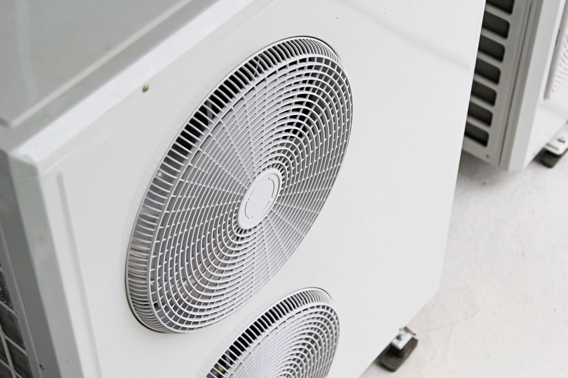 White air conditioning unit with fan grilles.