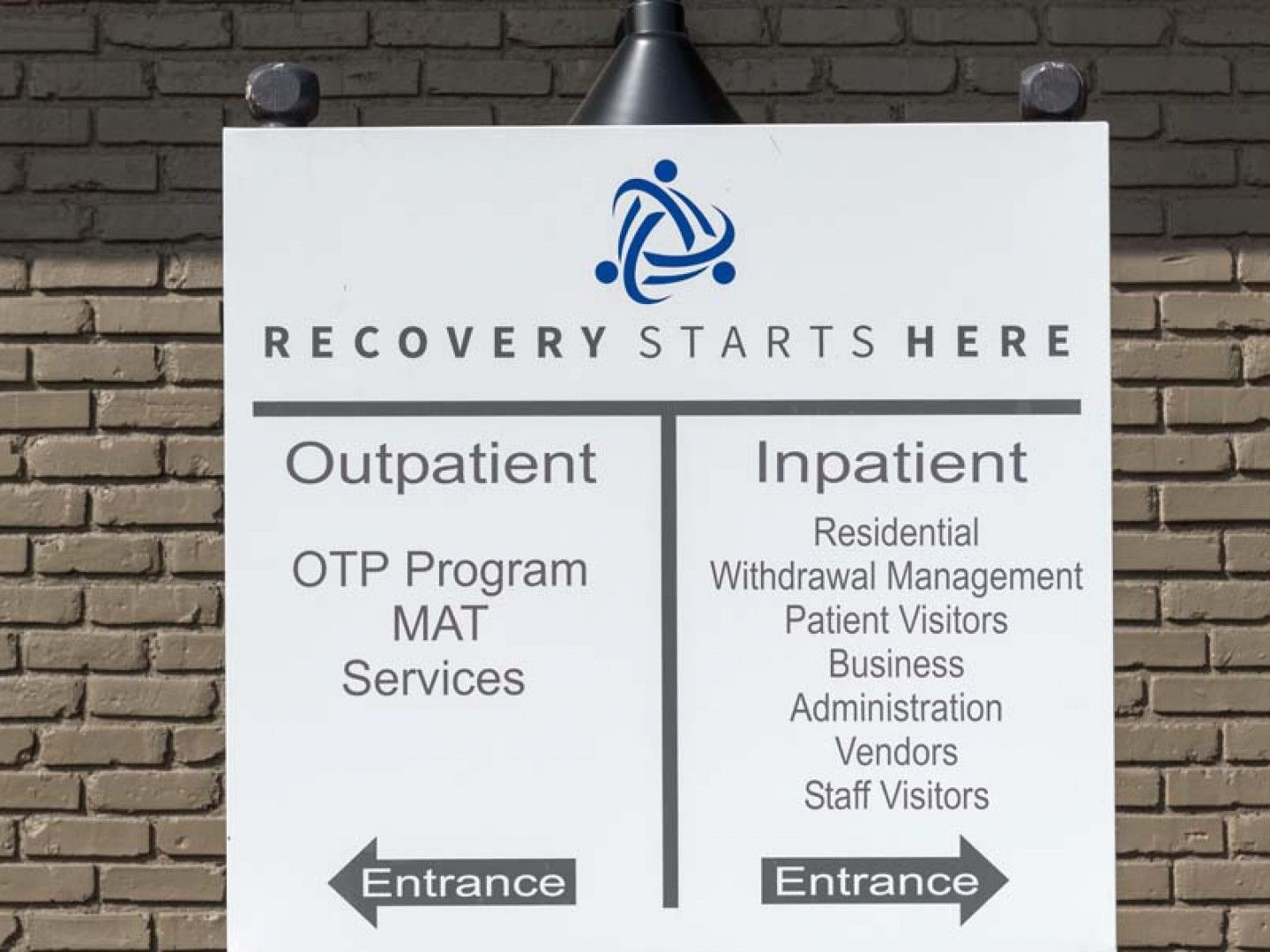 Sign indicating outpatient and inpatient services for recovery, with entrances.