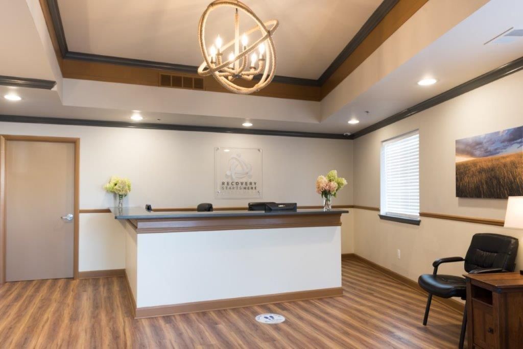 Reception area with desk, artwork, and chandelier.