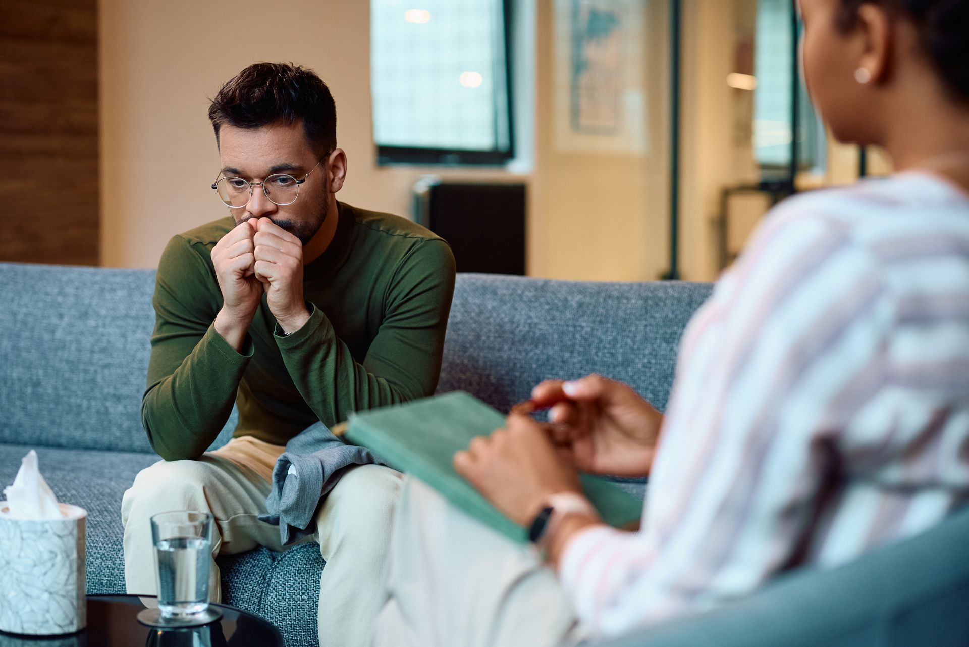 People in a circle, hands clasped, at a support group session.
