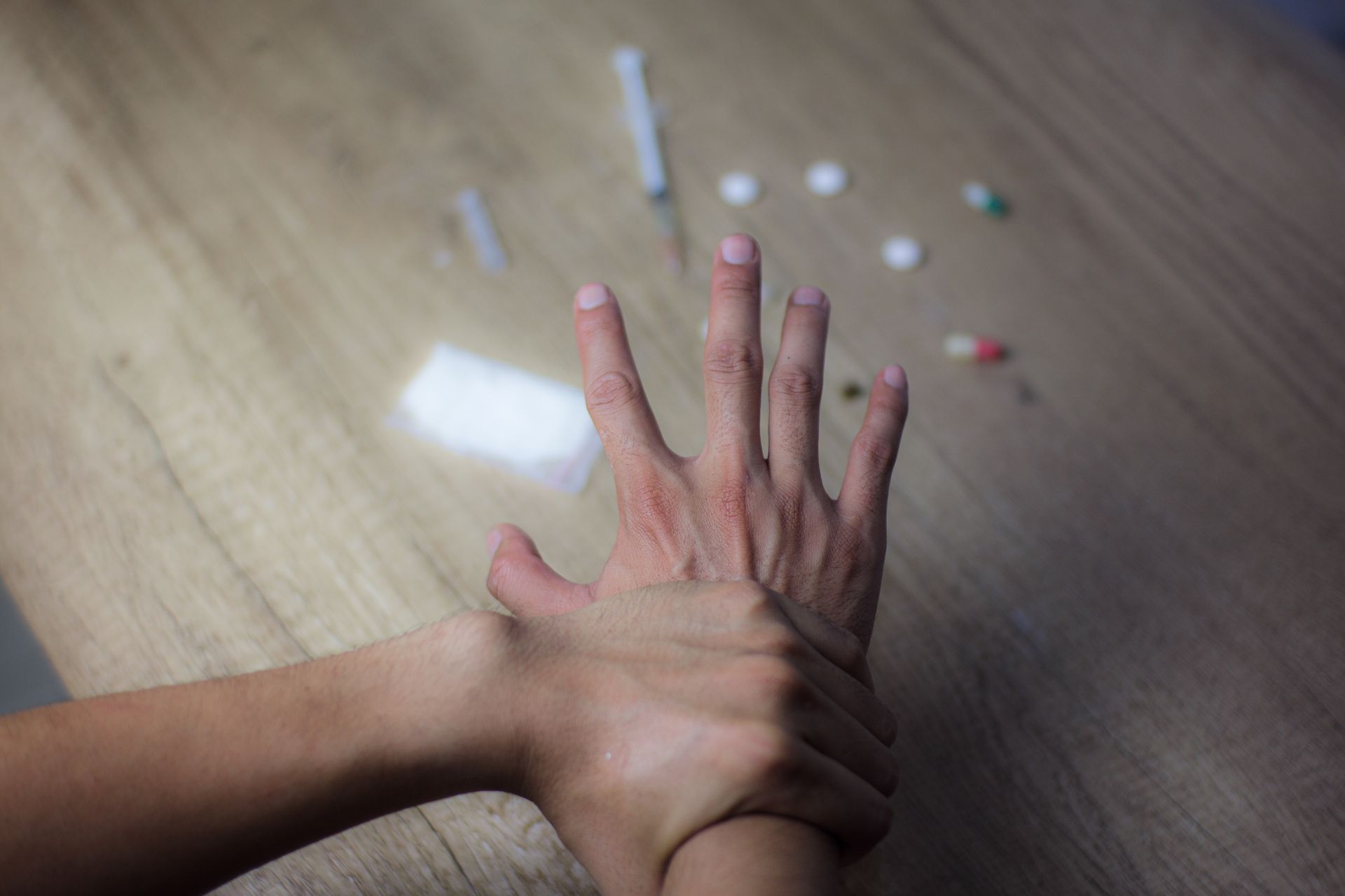 People in a circle, hands clasped, at a support group session.