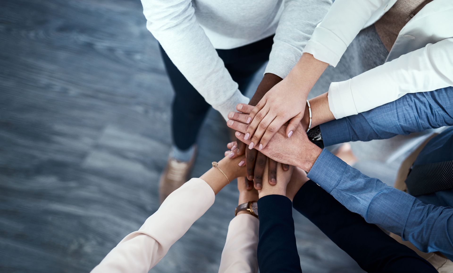 People in a circle, hands clasped, at a support group session.