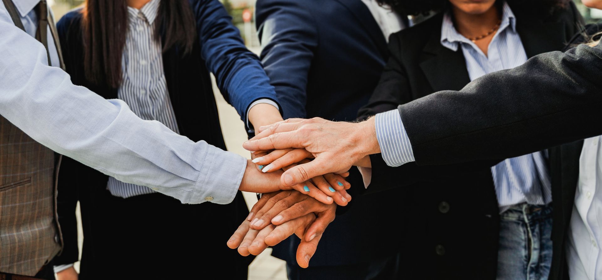 People in a circle, hands clasped, at a support group session.