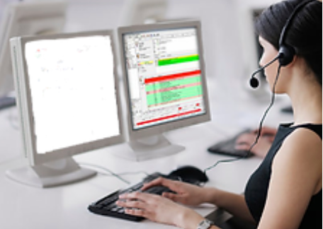 A woman wearing a headset is working on a computer