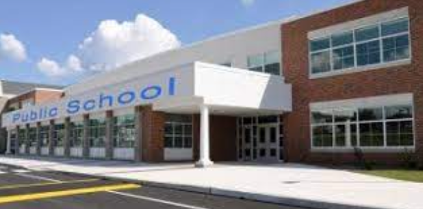The front of a public school building with a lot of windows.
