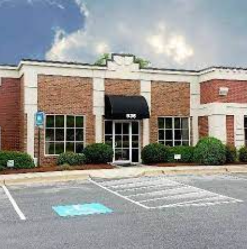 A large brick building with a handicapped parking spot in front of it.