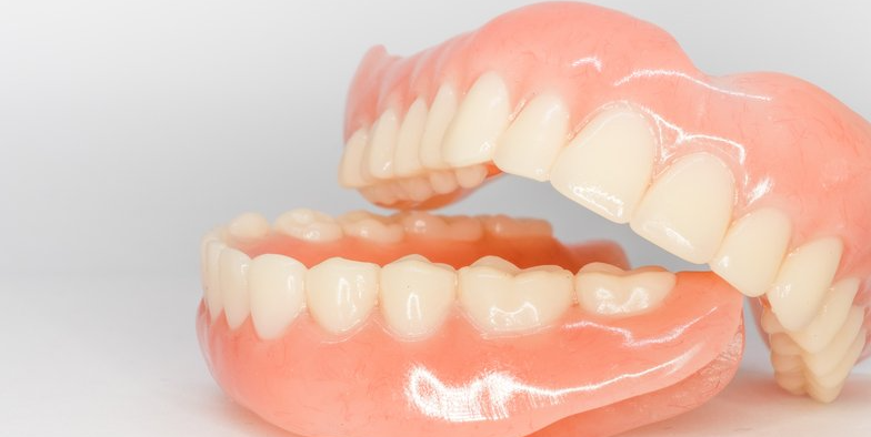 GILROY DENTAL SMILES_Dentist and assistant examining a patient's teeth in a dental office.