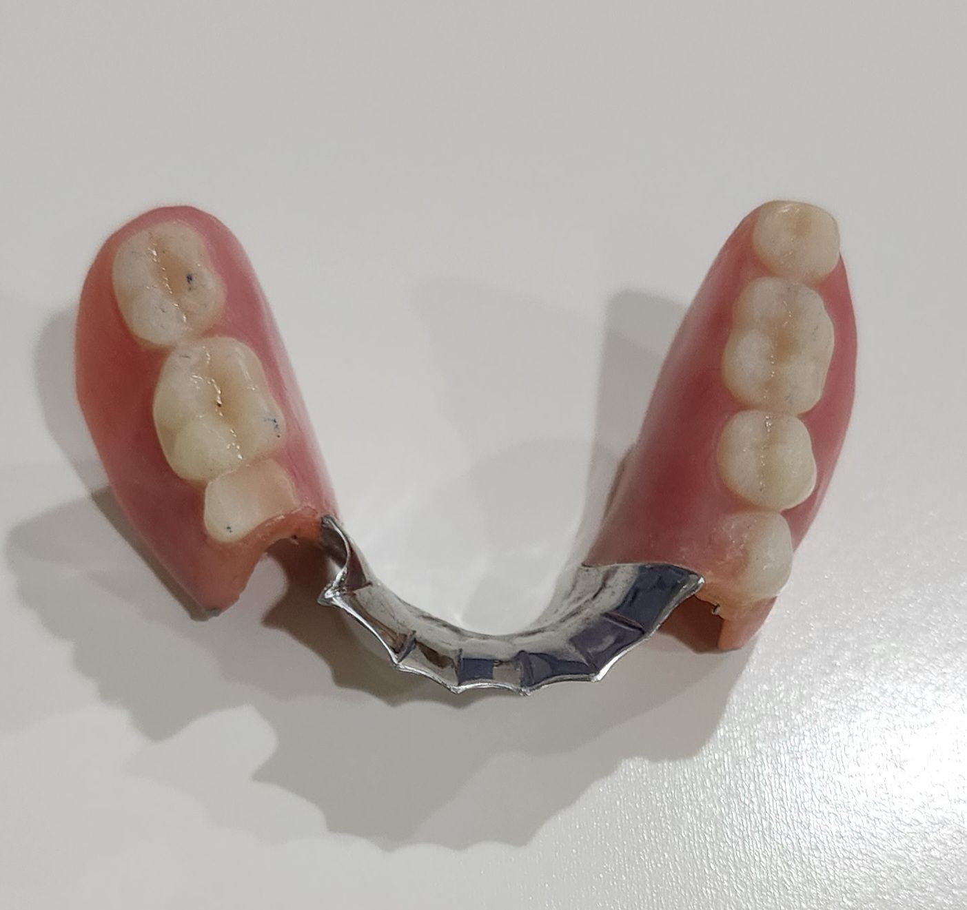 Smiling person, hands on cheeks, showing teeth.