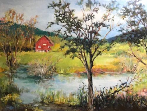 Rural landscape with a red barn, pond, and trees under a cloudy sky