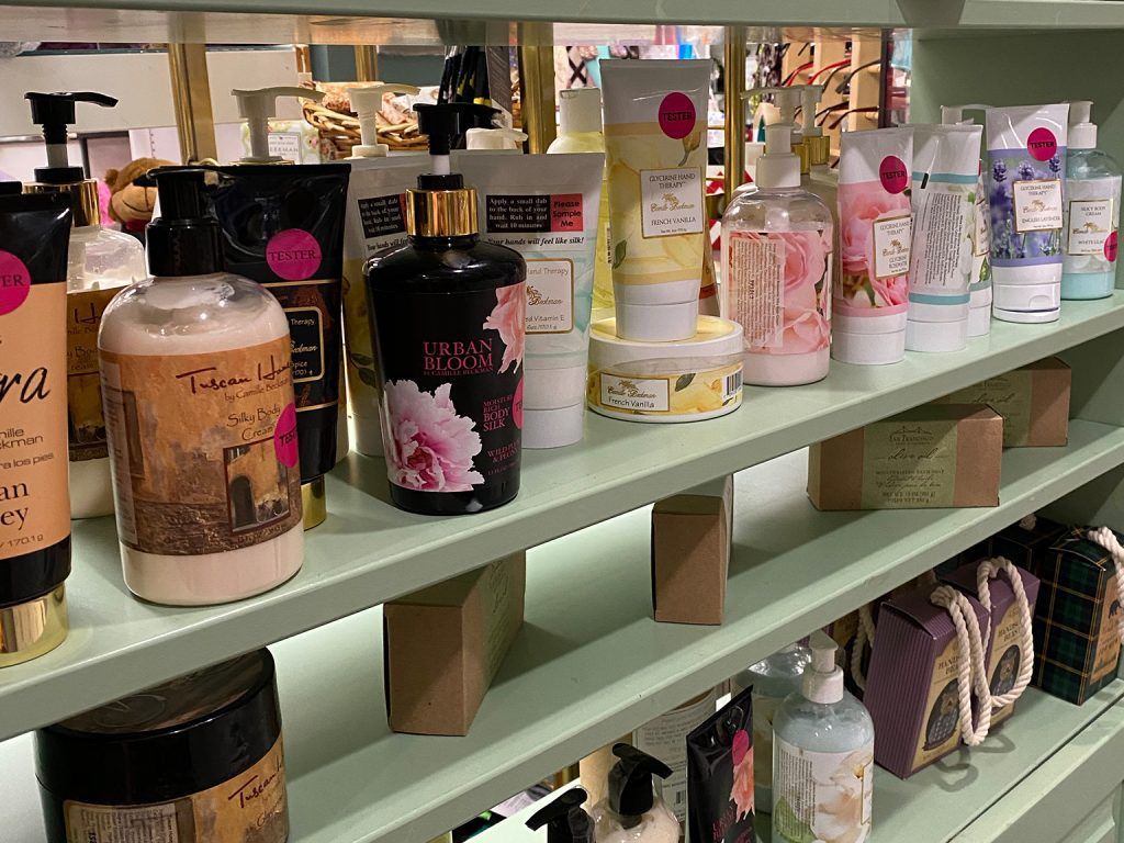 Shelves of pastel candles and bath products displayed in a store aisle