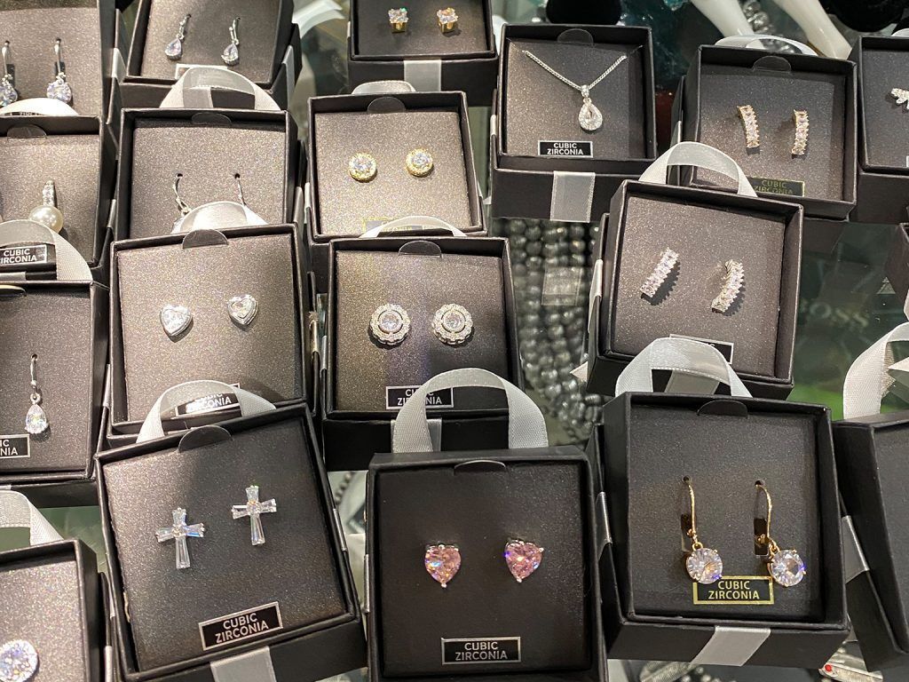 Black jewelry display cards with assorted earrings arranged in rows on a market stall