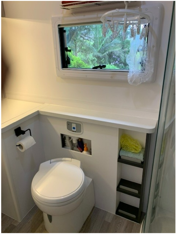 A bathroom with a toilet and a window.