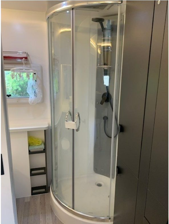 A bathroom with a shower stall and a window.