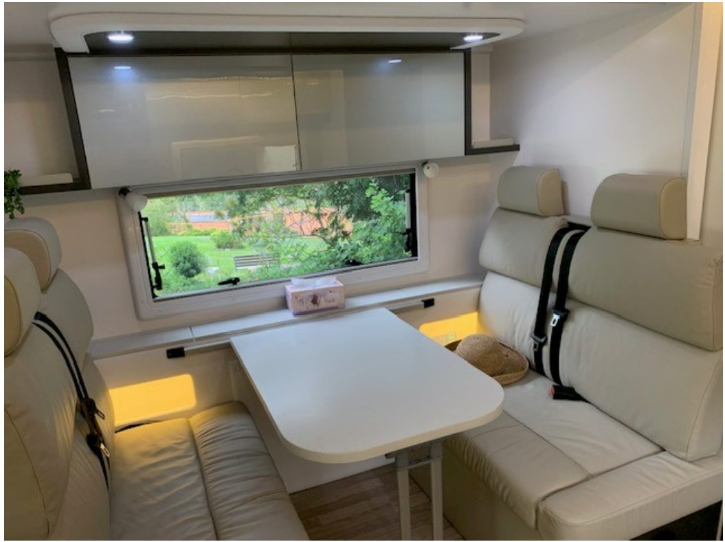 The inside of a camper van with a table and a window.
