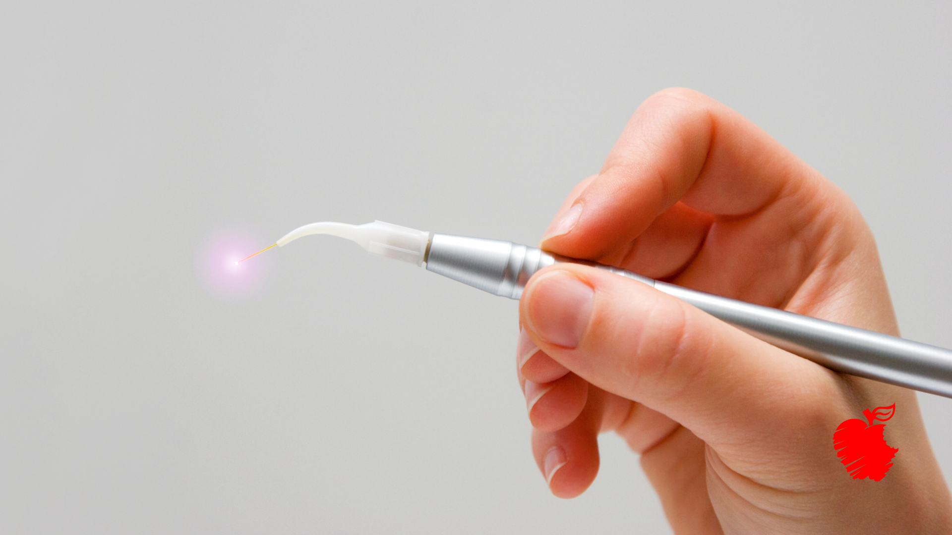 A person is holding a pen with a light coming out of it.