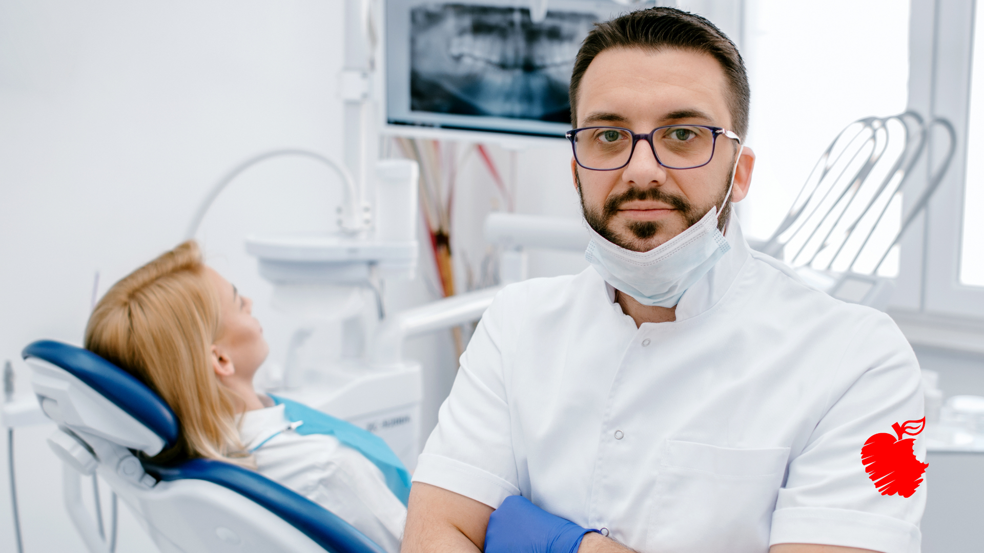 A dentist is standing in front of a patient in a dental chair.