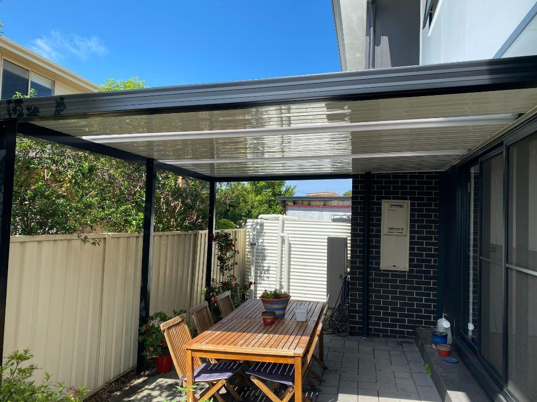 A Table And Chairs Under a Covered Area — Newcastle Patio Covers In Wallsend, NSW