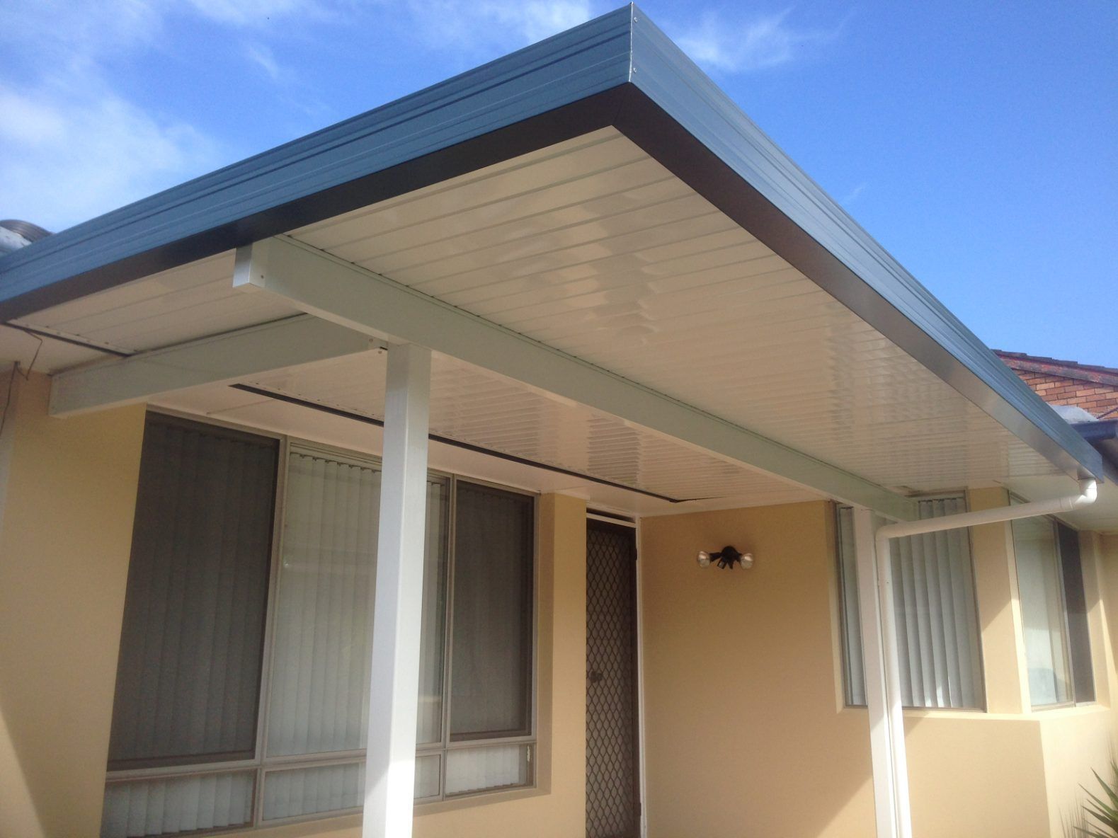 A House With A Covered Porch And A Blue Sky In The Background — Newcastle Patio Covers In Wallsend, NSW