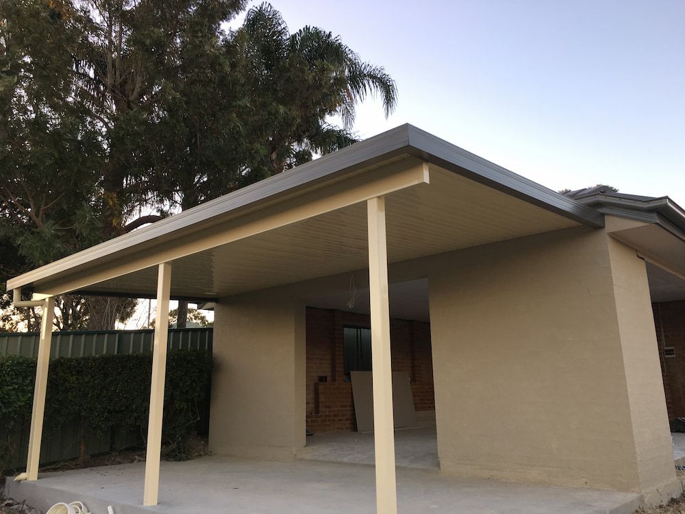 A House With A Porch And A Tree In The Background — Newcastle Patio Covers In Wallsend, NSW