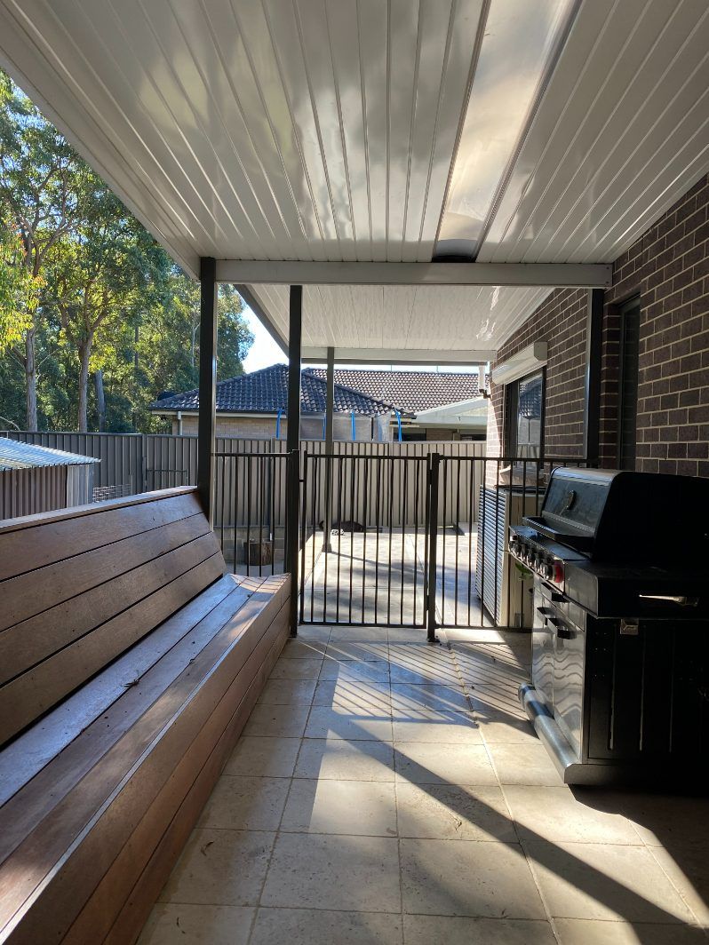 A Wooden Archway Over A Brick Walkway — Newcastle Patio Covers In Wallsend, NSW