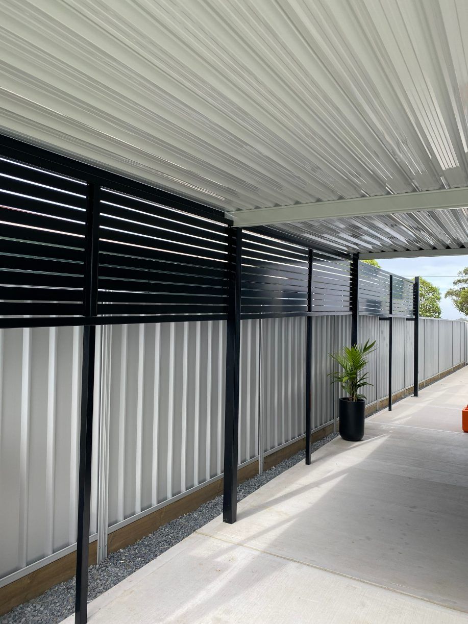 A Covered Walkway With A Fence And A Potted Plant — Newcastle Patio Covers In Wallsend, NSW