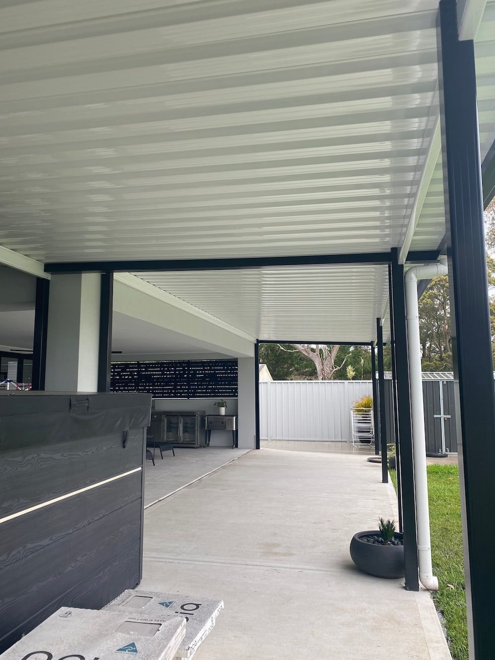 A Patio With A Covered Area And A Table Underneath It — Newcastle Patio Covers In Lake Macquarie, NSW