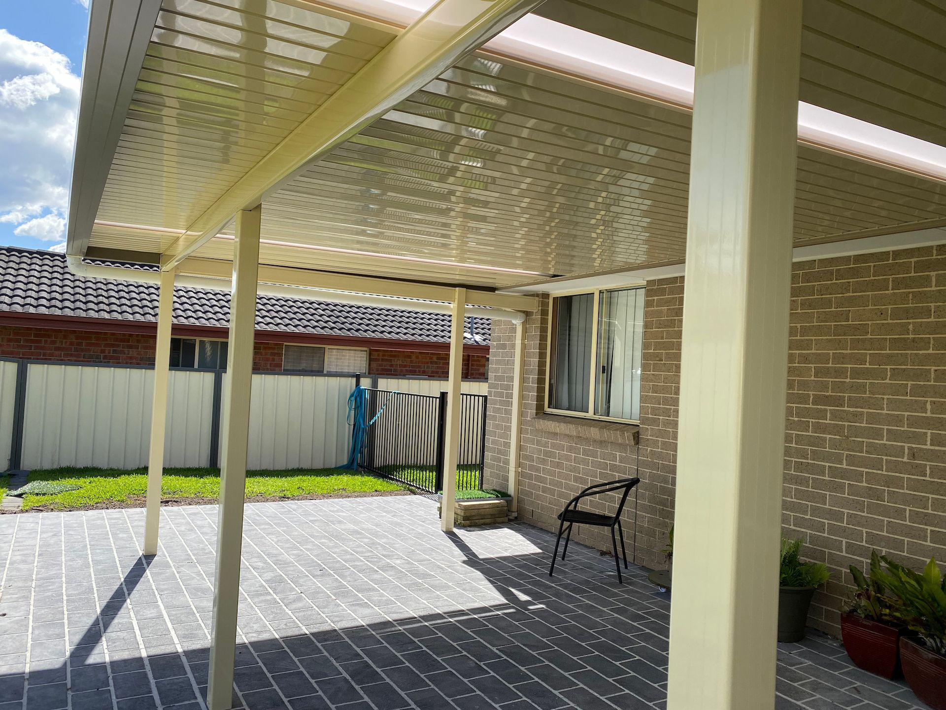 A Colourbond SteelCream Verandah With A Chair Underneath— Newcastle Patio Covers In Wallsend, NSW