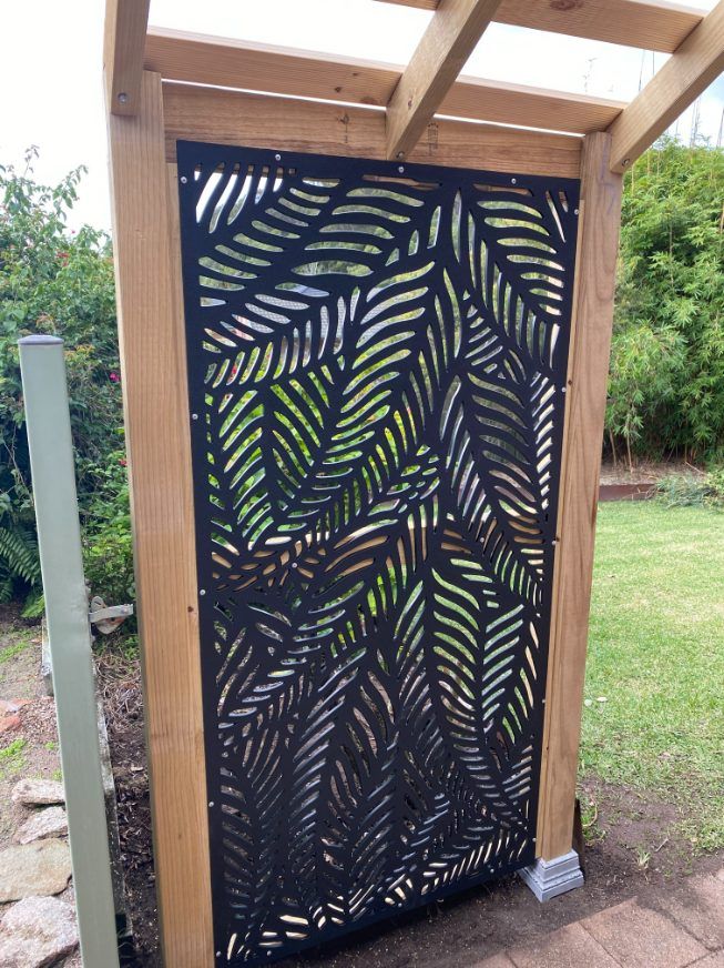 A Wooden Pergola With A Metal Screen On Top Of It — Newcastle Patio Covers In Wallsend, NSW