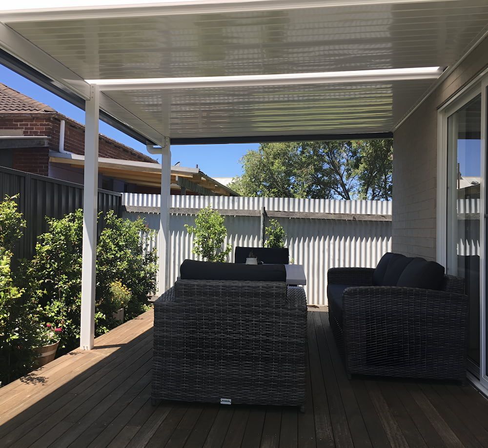 A Patio With Wicker Furniture And A White Roof — Newcastle Patio Covers In Maitland, NSW