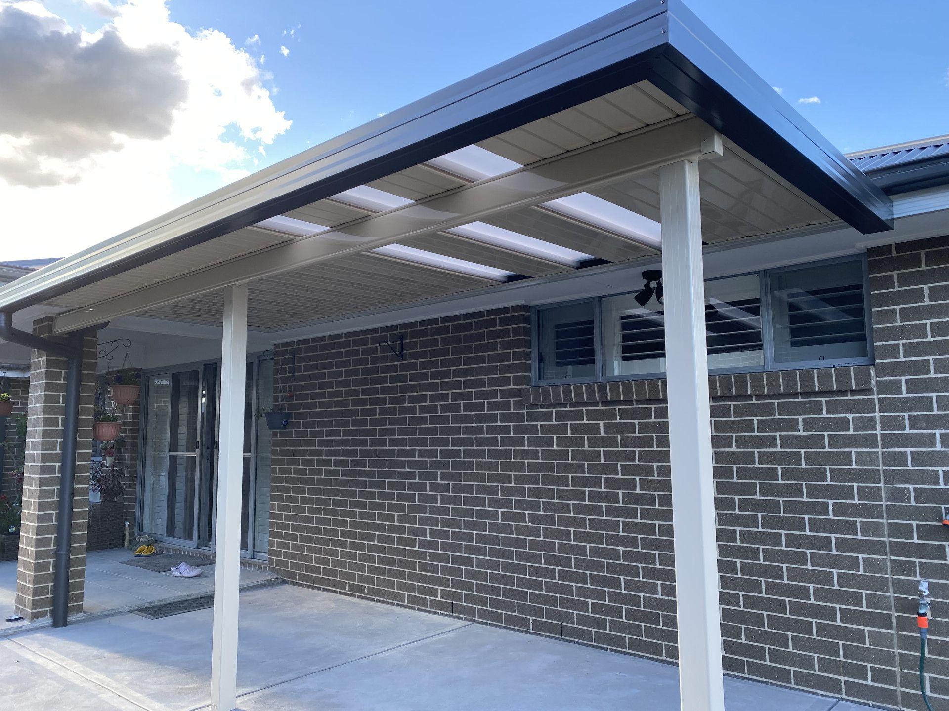 A Patio Cover Attached To A Brick House— Newcastle Patio Covers In Wallsend, NSW