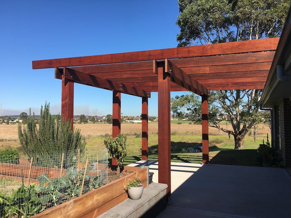A Wooden Pergola With A Bench Underneath It — Newcastle Patio Covers In Wallsend, NSW
