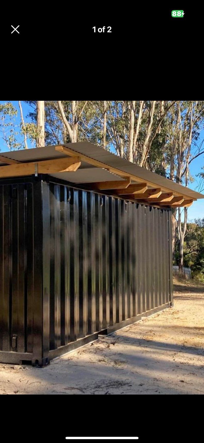 A Black Shipping Container With A Wooden Roof — Newcastle Patio Covers In Wallsend, NSW