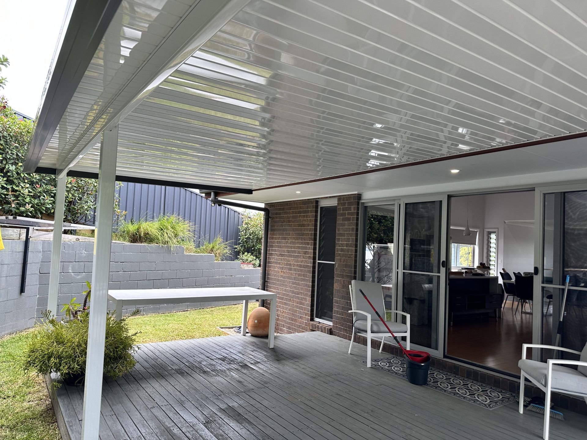 A White Colourbond Patio Cover With A Brick House — Newcastle Patio Covers In Wallsend, NSW