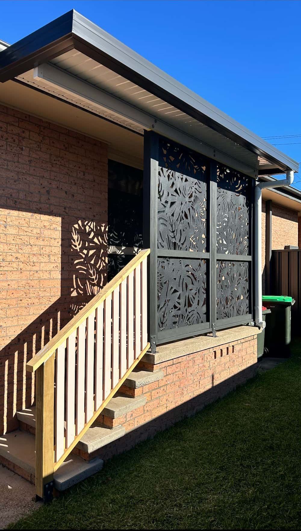 A House With A Verandah And A Black Metal Shade With Stairs Leading Up To It— Newcastle Patio Covers In Wallsend, NSW