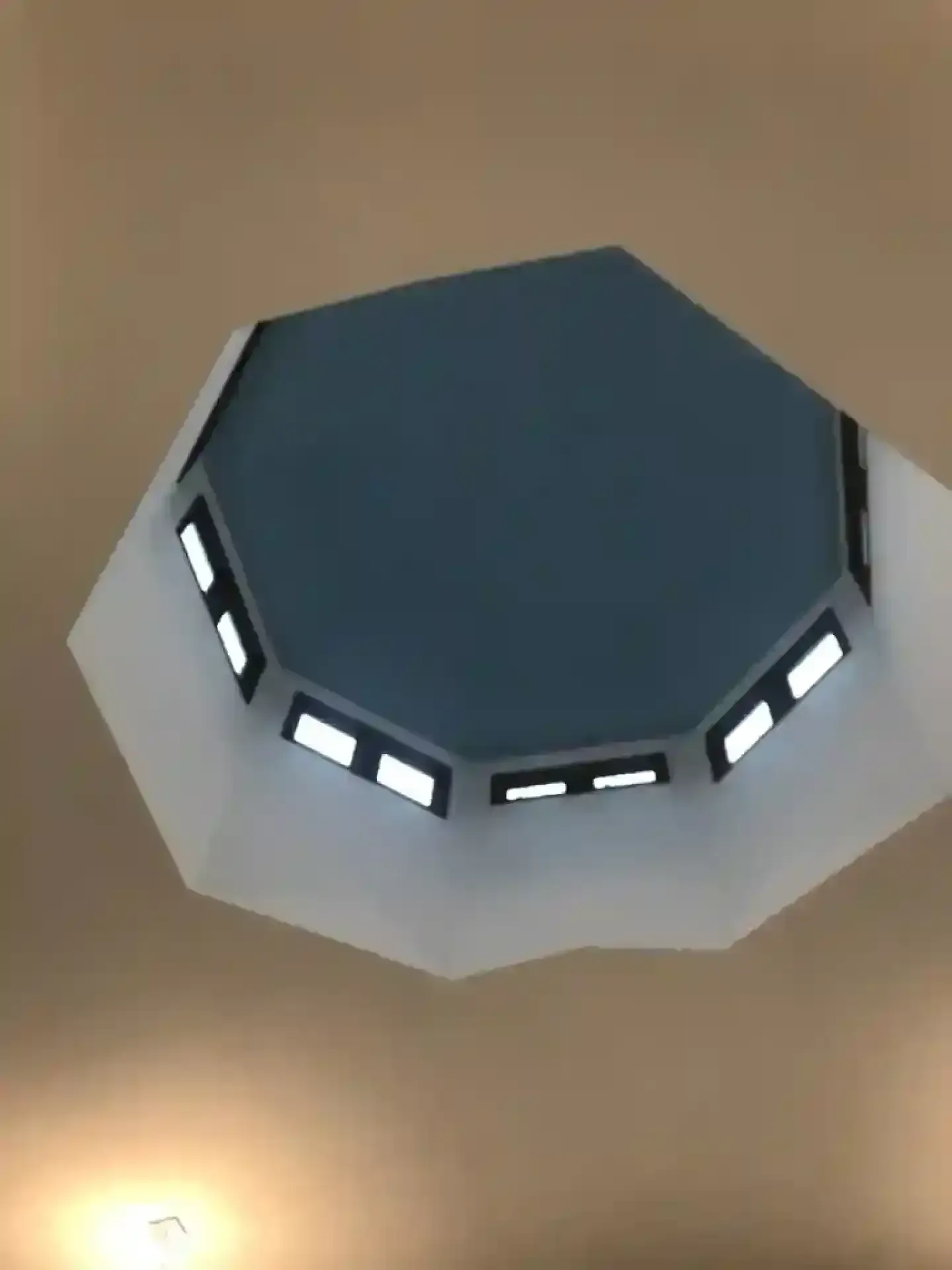Octagonal skylight in a beige ceiling with small rectangular lights around the opening