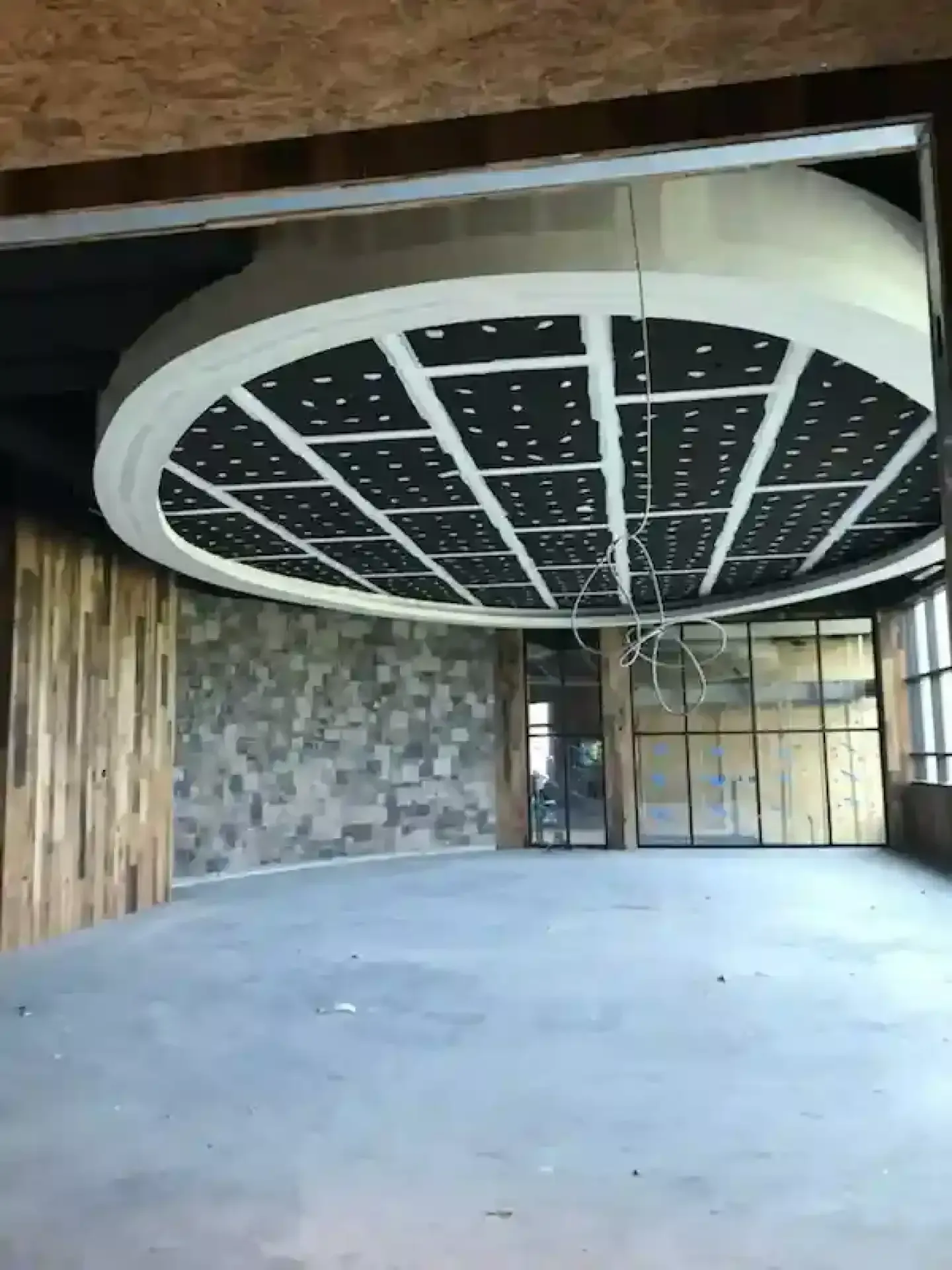 Empty modern lobby with a large circular ceiling feature and unfinished walls