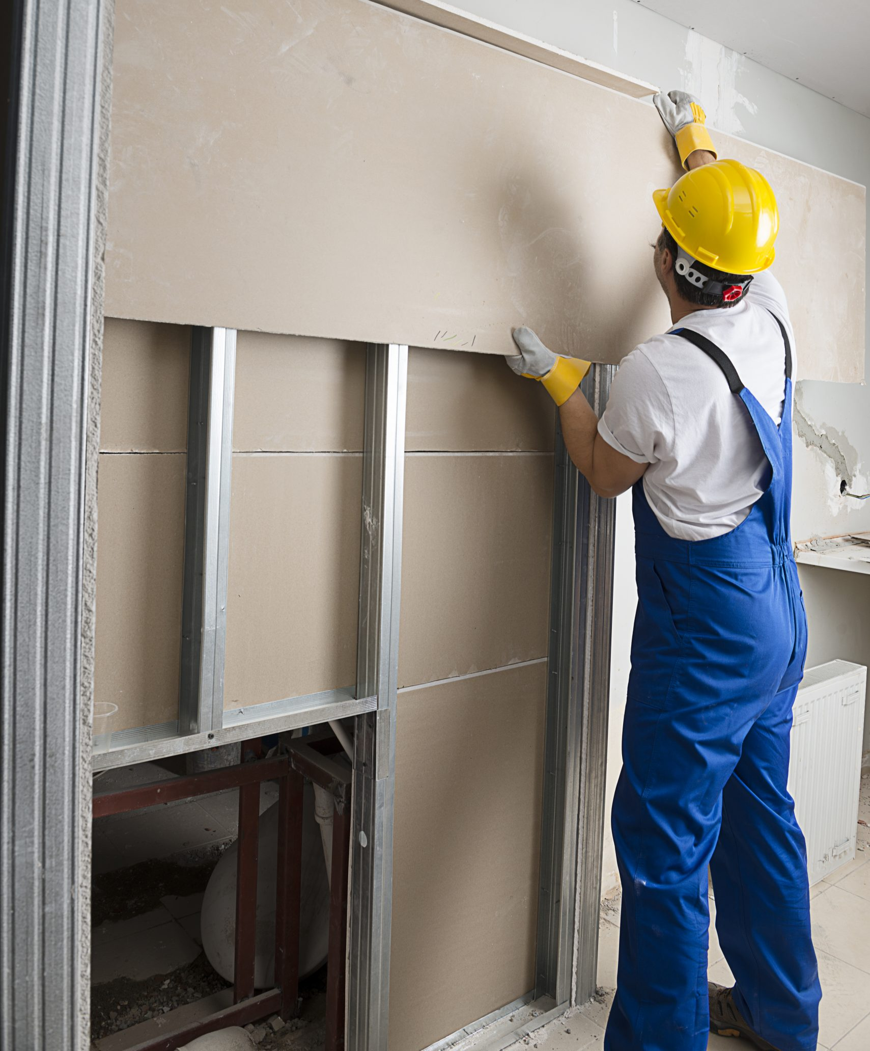 A worker hanging drywall.