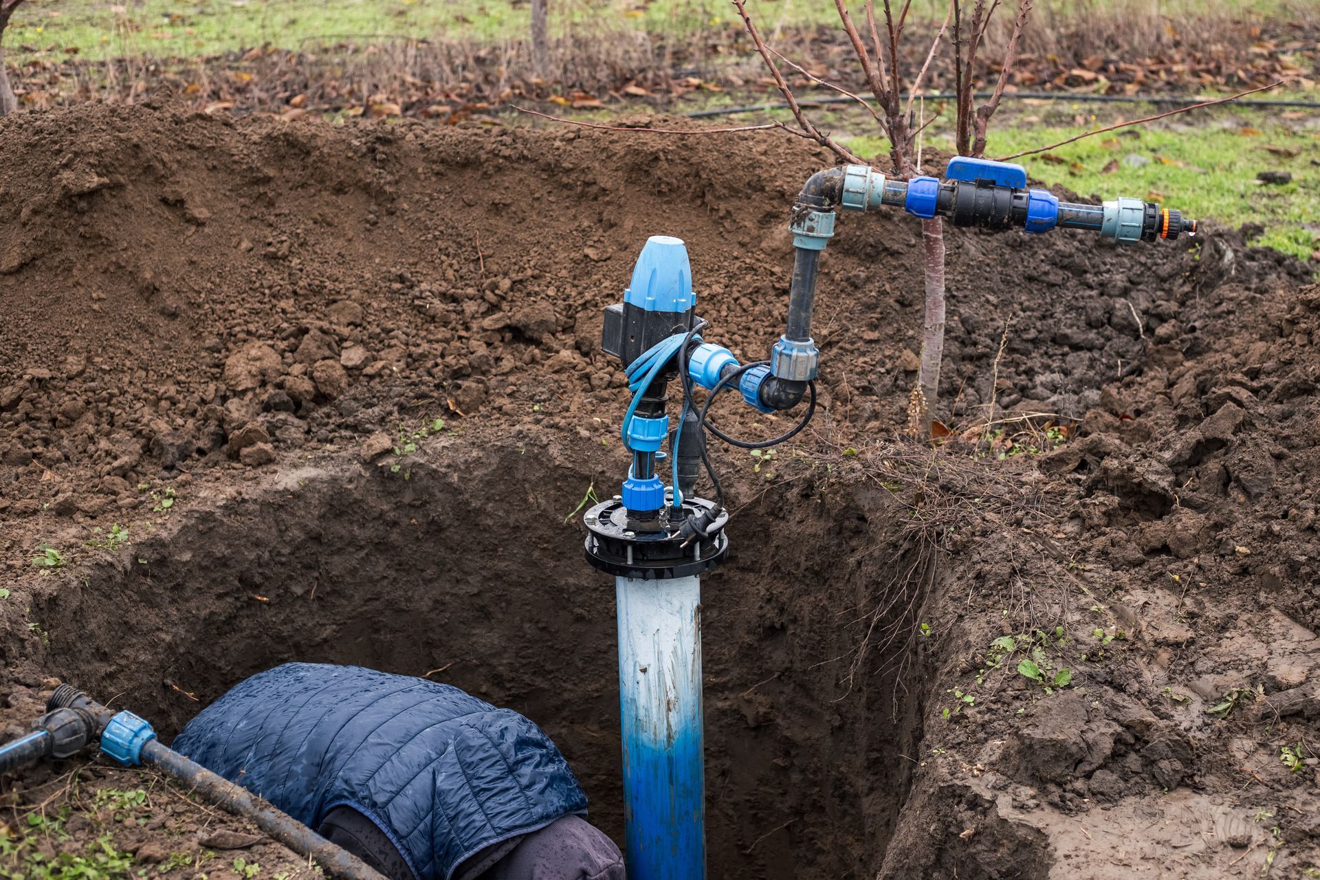 A worker installs a water intake unit in a well. A worker installs a water intake unit in a well.