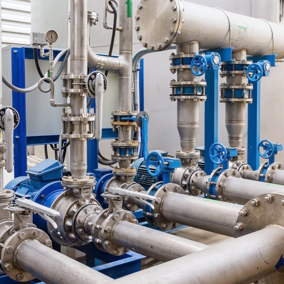 Pipes and valves, mostly metal and blue, in a utility room.