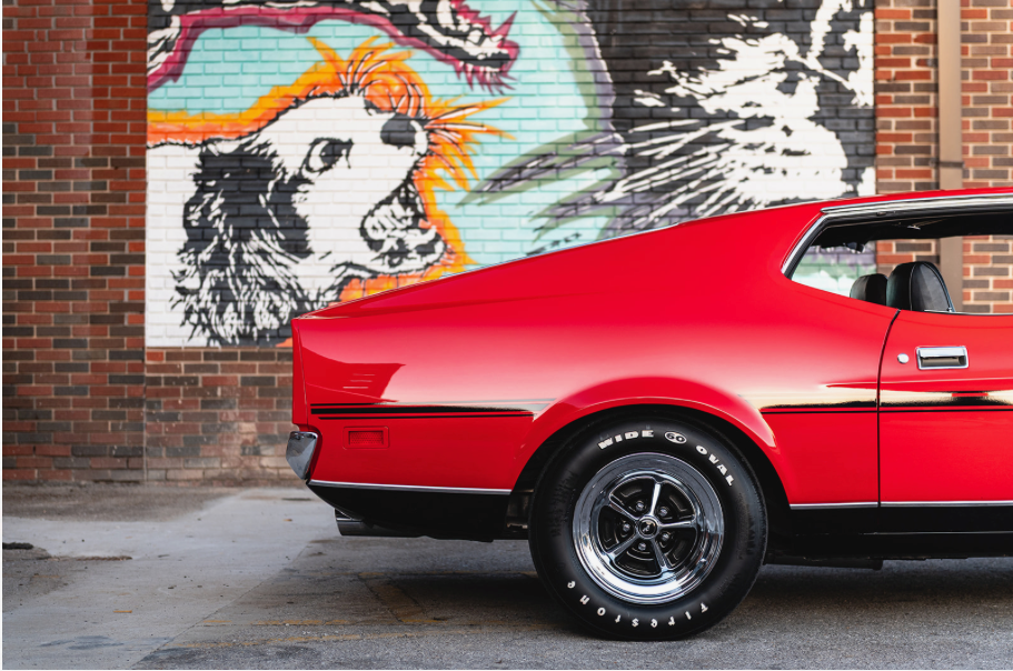 classic 1970's red and black mustang reflecting night lights with shinny paint