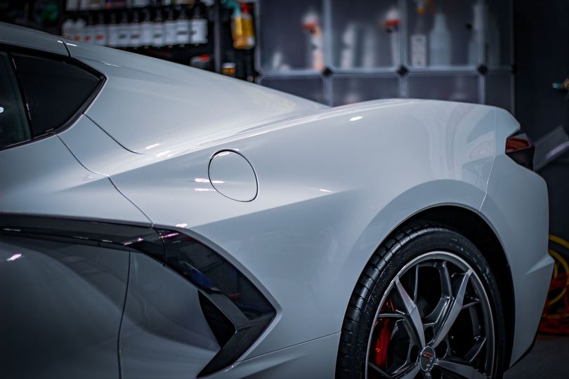 A white sports car is parked in a garage.