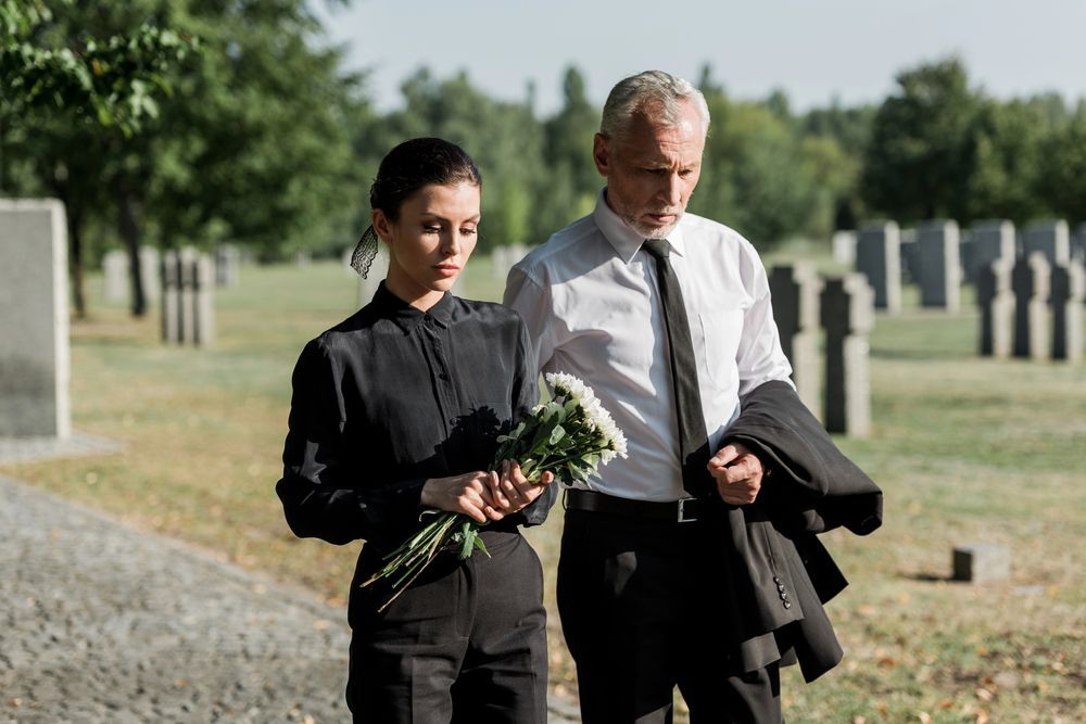 Man and woman walking in a cemetery after a funeral