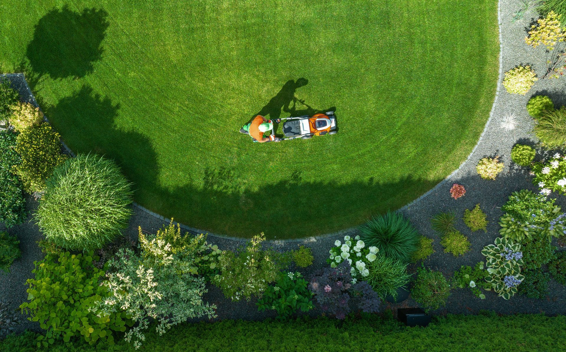 Top-down view of a person lying on grass beside a bicycle in a green park garden