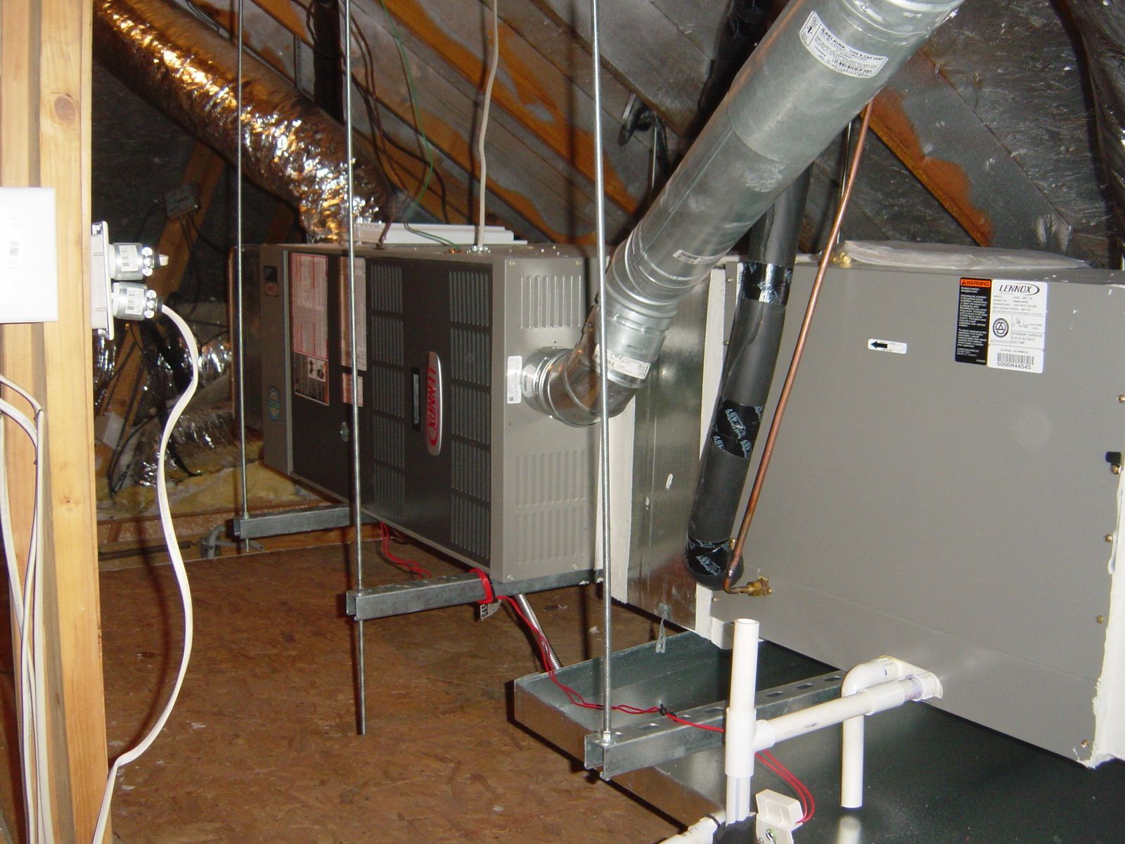 Attic HVAC system with ductwork, furnace, and pipes in an unfinished crawl space