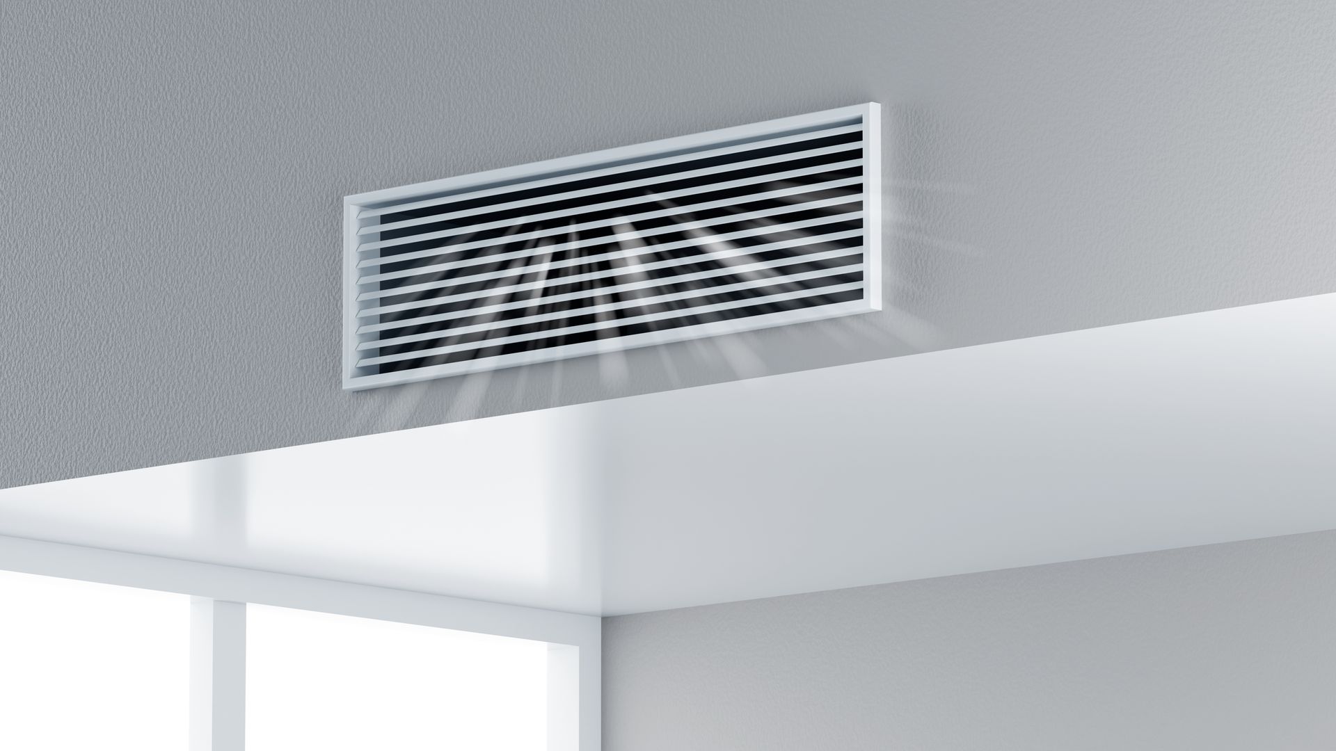 White ceiling air vent above a doorway with sunlight streaming into a room