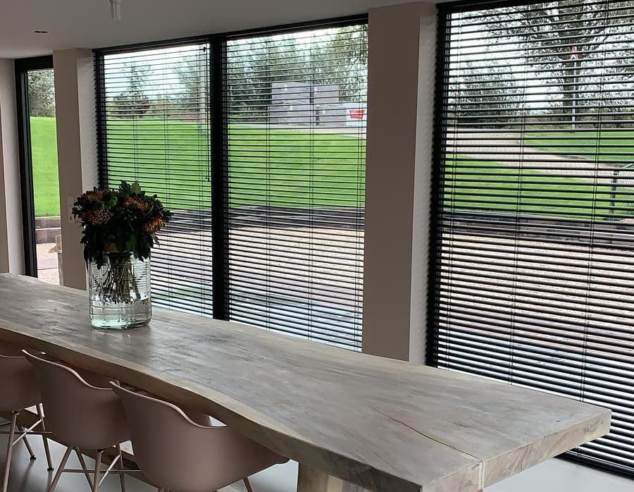 een eettafel met een vaas met bloemen erop